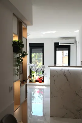 Recepcija sa mermernim pultom, biljkama i pogledom ka ordinaciji